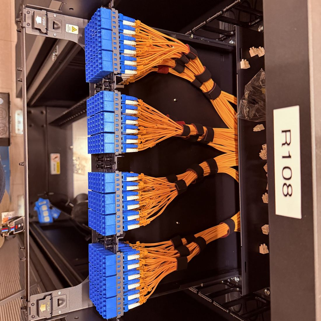 Optical distribution frame with orange single-mode jumpers dressed into LC adapter packs