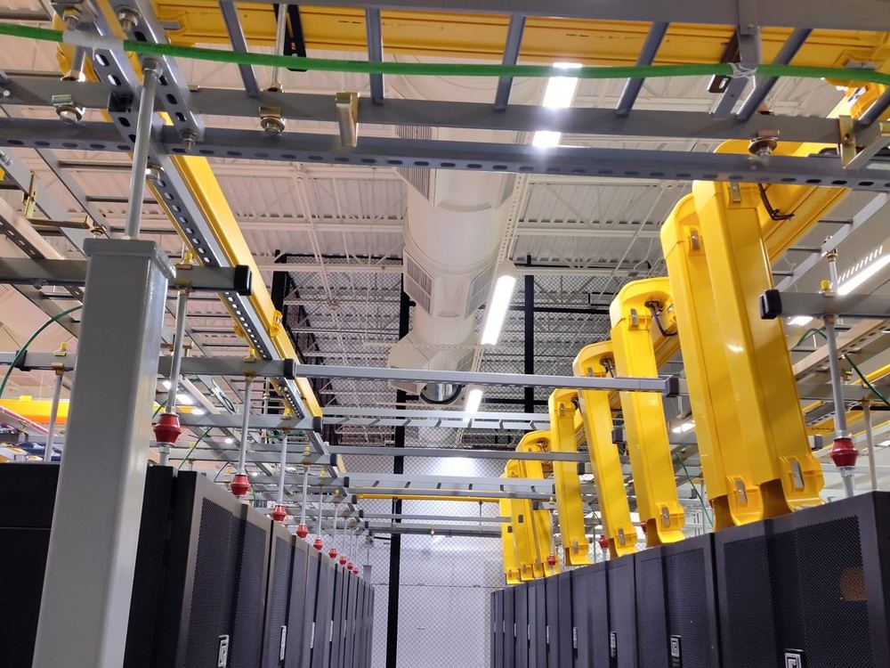 Overhead fiber raceway and ladder rack installed above a row of cabinets
