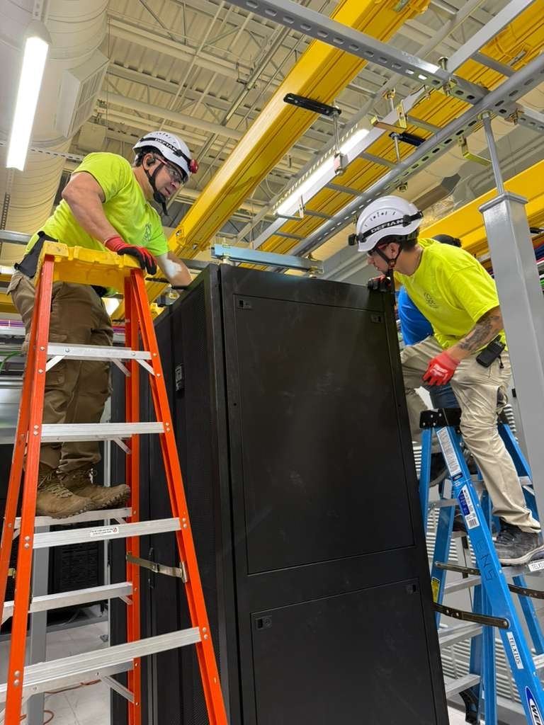 DDC crew positioning 42RU cabinet during on-site installation