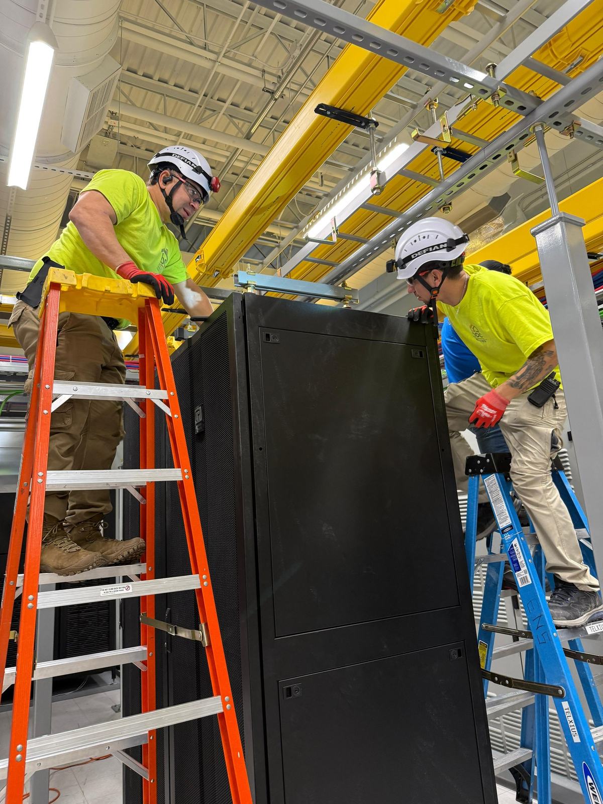 Crew positioning a 42RU cabinet during on-site installation