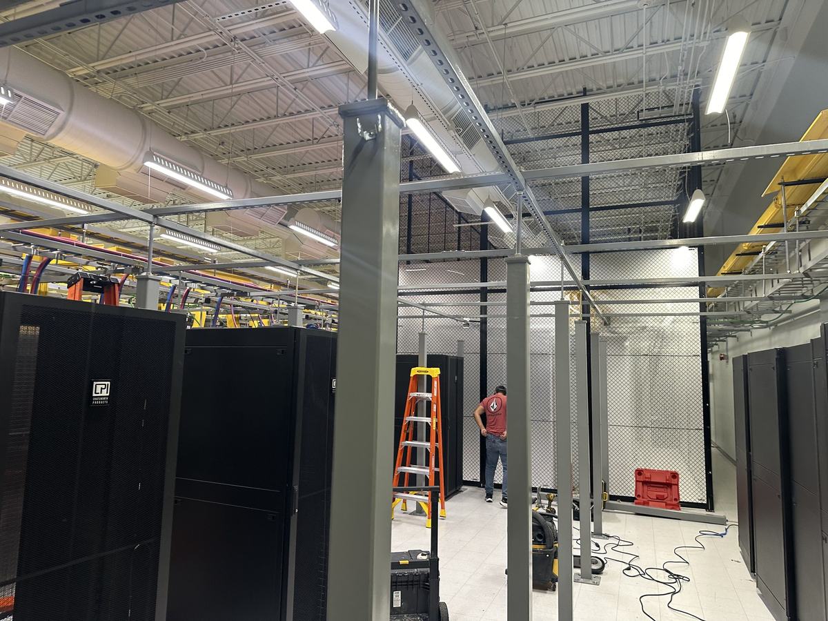 Cage build-out in progress with overhead pathway under construction