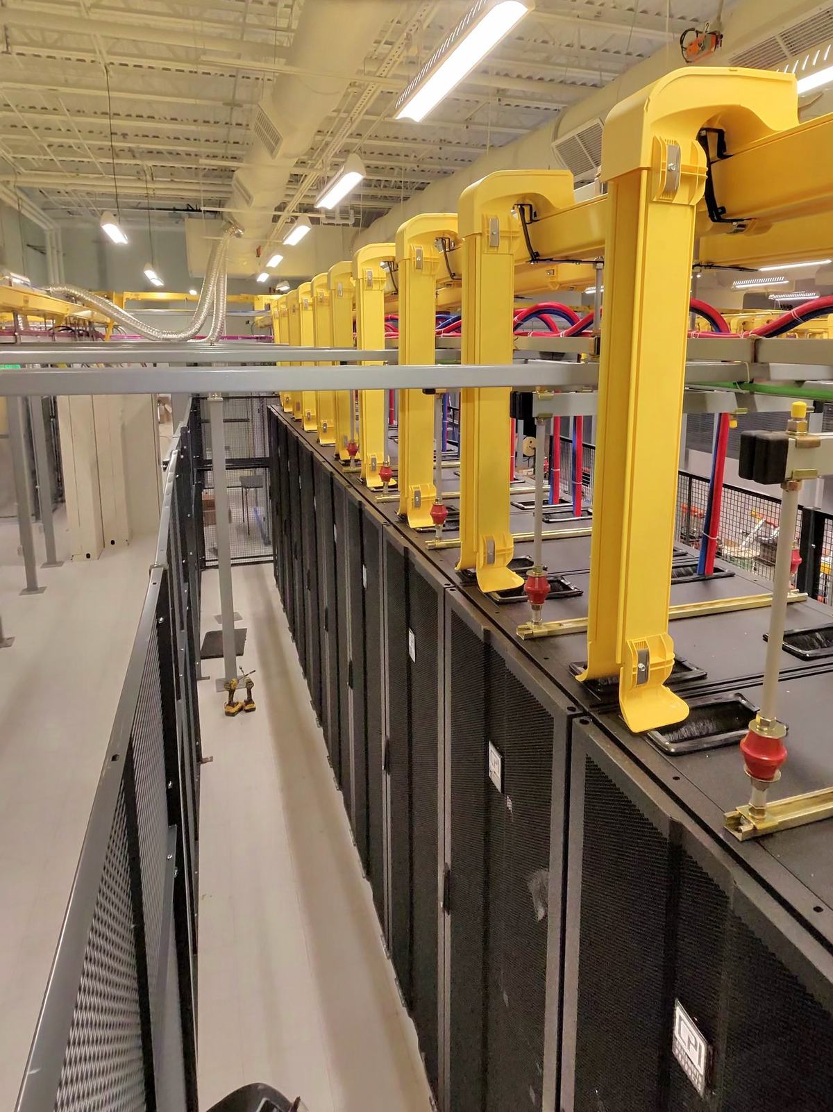 Overhead power whips above a row of cabinets