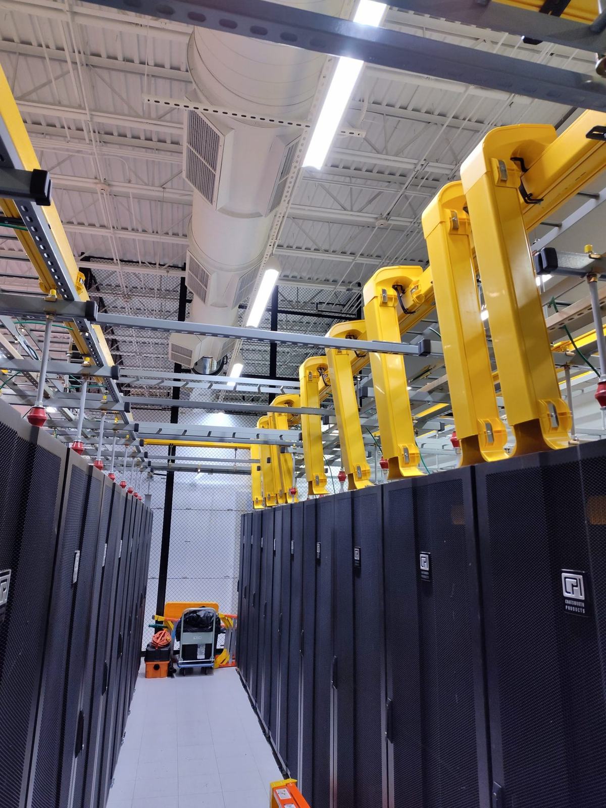 Rows of overhead fiber runner above a cabinet aisle